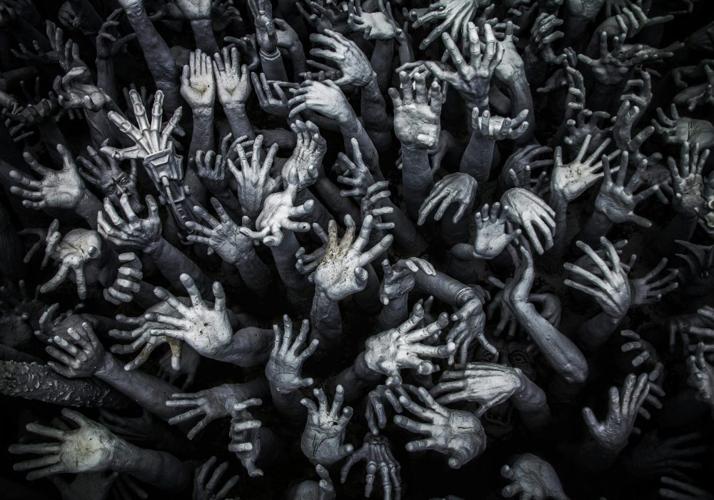 Projects A haunting display of numerous grey hands reaching upward at Wat Rong Khun, Thailand.
