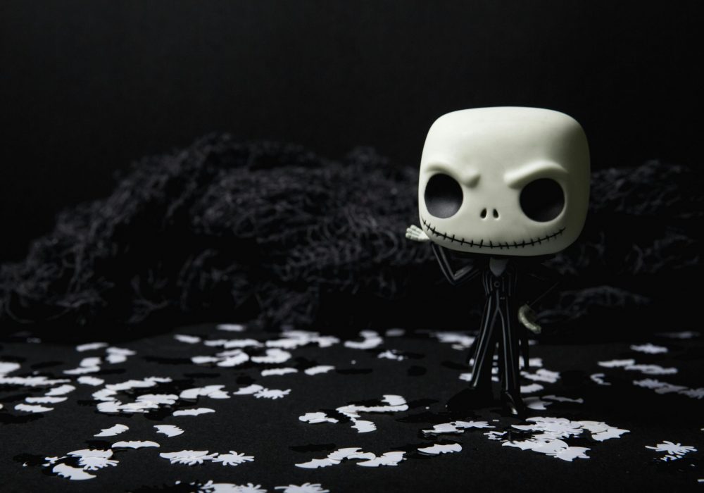 Projects A creepy toy figure on a dark background adorned with eerie white shapes, ideal for Halloween themes.